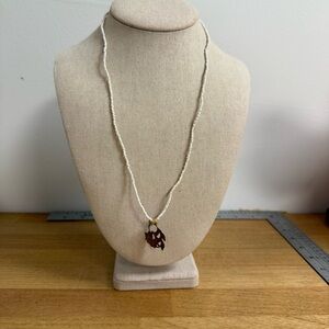 Antique gold tone flower pendant on white seed bead chain